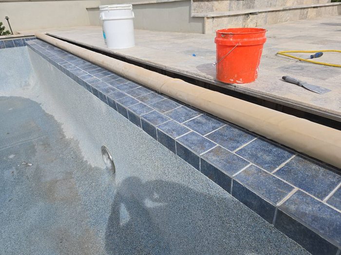 New waterline tile and coping installed during a pool remodel in Tempe, AZ