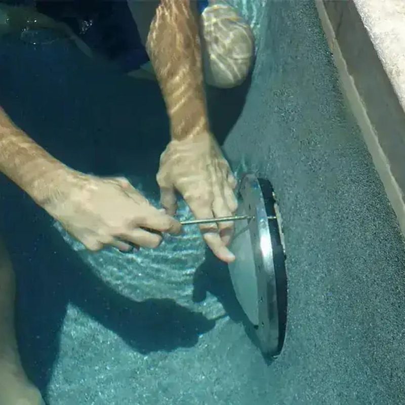 Pool light installation in Gilbert, AZ - technician installing a pool light fixture, Blue Lagoon Pool Management